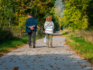 Clecy, Normandy, October 4, 2025. An elderly couple walks along a forest path. An elderly couple walks leisurely along a rural path surrounded by autumn trees in Normandy, France. The scene depicts