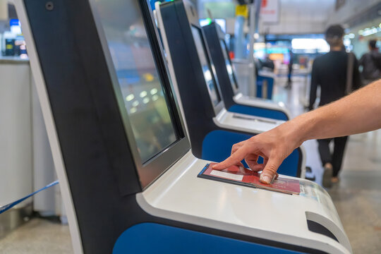 Traveler scanning passport at self service check-in kiosk in modern airport terminal. Automated machine for ease and efficiency of air travel. Technology, automation and digital identity verification