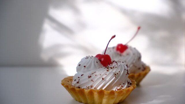 Cupcakes, sand baskets with cream with Cherry Topping. Dusk. Sunset sunlight and atmospheric mood. Cupcakes  with white pink meringues on top and chocolate, muffins