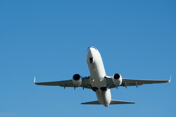 Airplane in the blue sky. A white airplane taking off against a blue sky