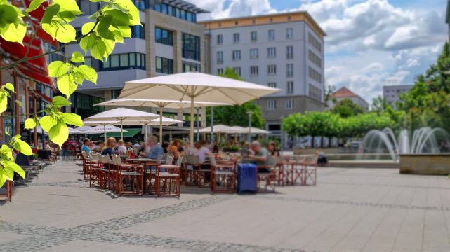 motion blur time lapse of a urban scene with a restaurant outdoors in down town on a sunny summer day, Magdeburg, Saxony-Anhalt, Germany
