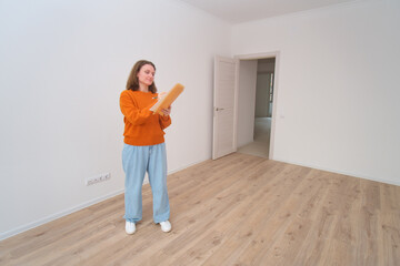 Woman inspecting new apartment. Homeowner taking notes. Real estate purchase and renovation...