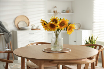 Beautiful sunflowers in vase on dining table at home