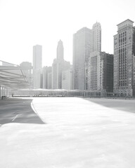 Fototapeta premium Grey cityscape silhouette with buildings on a foggy day, road in foreground