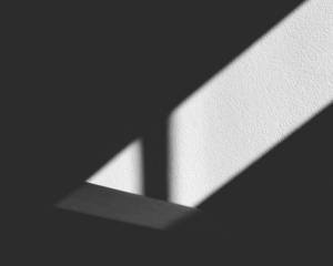 Light beam and shadows on a textured surface, contrasting light and dark elements