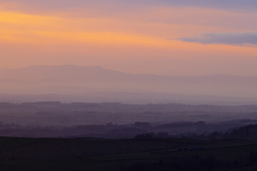 Sun setting over the Lake District Mountains looking over the eden valley. Cumbria, England, UK.