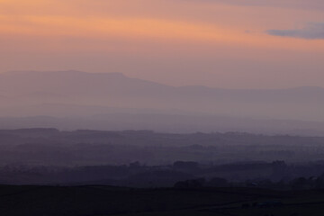 Sun setting over the Lake District Mountains looking over the eden valley. Cumbria, England, UK.