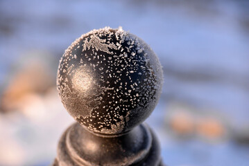 Ice crystals and snowflakes on a metal ball