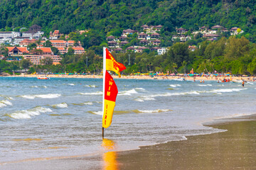 Patong Beach Phuket with red flag turquoise blue water Thailand.