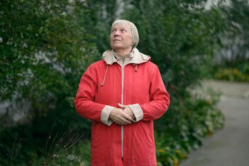 Older woman in red jacket enjoying nature.