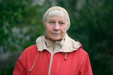 Older woman in red jacket enjoying nature.