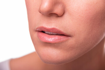 A woman's mouth and lower face, emphasizing natural lips and skin texture, is presented on a white background.