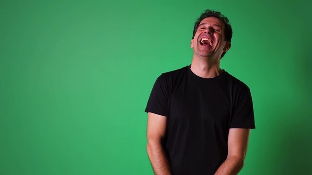 Man's infectious laughter in slow motion on green screen, a humorous stock video perfect for memes, reaction videos, or comedic content creation