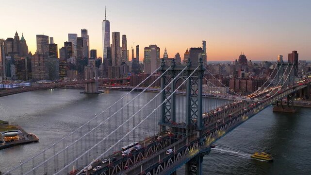 Aerial view of the Manhattan Bridge with a backdrop of skyscrapers, including World One, displaying a stunning skyline at sunset, New York, New York, United States.