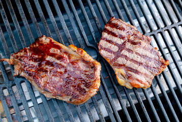 Juicy steaks grilling on an outdoor barbecue during a sunny afternoon cookout