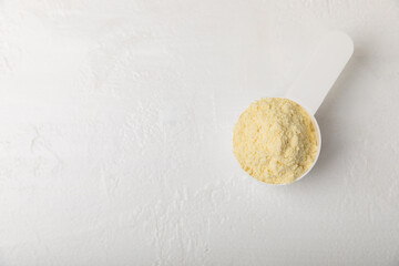 Protein powder. A spoonful of protein powder on a table. Different flavors of whey protein powder. Sports nutrition concept. Gym. Amino acid food supplement, creatine powder. Copy space.