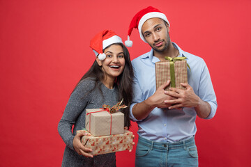 Man and woman dressed in festive attire celebrating new year with gift boxes and tinsel