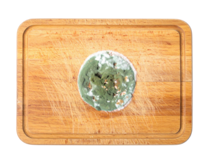 A circular mound of green mold is prominently displayed on a wooden surface, showcasing its texture and organic appearance.