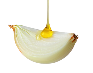 A halved onion with a drizzle of oil cascading from its surface.