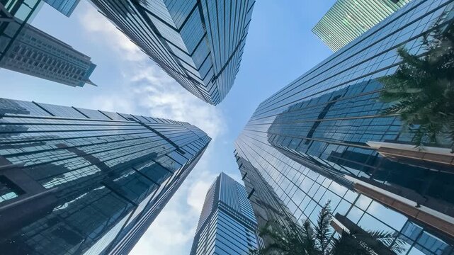 timelapse video of office tall building. Low angle view of skyscrapers office building in central business district with blue sky