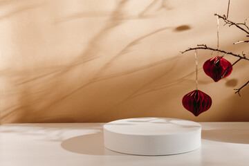 Empty winter podium with paper christmas balls at the background with aesthetic shadows. Christmas and new year background for product presentation, design, branding and gift