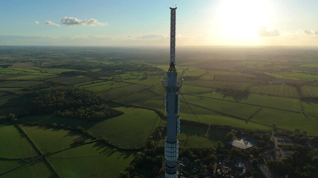 Aerial view of the Waltham on the Wolds transmitter rising above the patchwork fields bathed in the warm glow of the sunset, Melton Mowbray, England, United Kingdom.