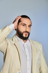 Obraz premium Handsome middle eastern man showcases elegance and style in vibrant studio setting