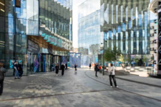 Blurred photo: a business center in a metropolis, modern office buildings with passing people. High quality photo