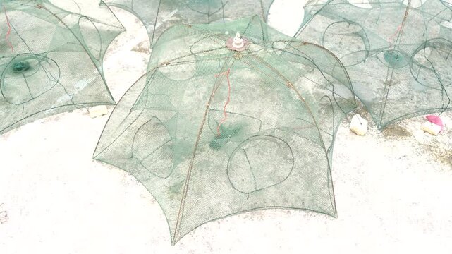 Close-up View of Green Fishing Nets Set on White Sandy Beach with Soft Natural Light Highlighting the Intricate Design Details and Textures