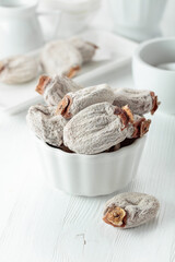 Dried persimmons on a white wooden table.