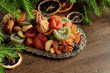 Assorted dried fruits and nuts on a silver tray.