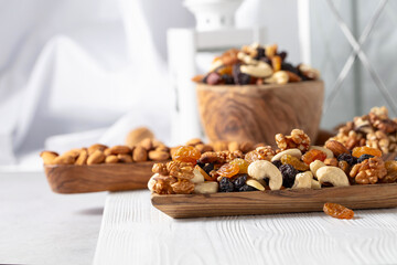 Mix of nuts and raisins on a wooden table.
