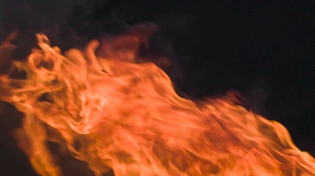Ignition Fury in the Dark. Bright and vivid bursts of flame captured in close-up, appearing dynamically against a deep black background. Perfect for use in visual effects, action scenes, or dramatic t