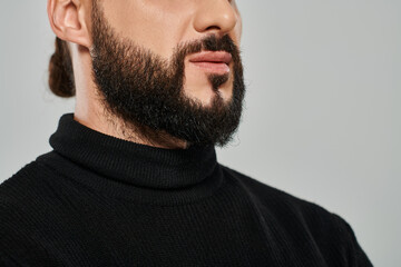 Obraz premium Charming Middle Eastern man with a beard showcasing modern fashion in a studio setting