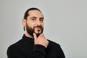 Handsome bearded man showcasing modern fashion in a studio setting
