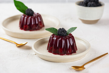 Jelly with fresh cherry and blackberry on light table with golden spoons. Healthy food, vegan, sugar, gelatin and lactose free.