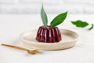 Jelly with cherry, blackberry and green cherry leaves in a plate. Vegan, sugar and lactose free.