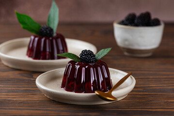 Berry jelly with fresh cherry, blackberry and green cherry leaves on wooden table. Healthy food, vegan, sugar, gelatin and lactose free.