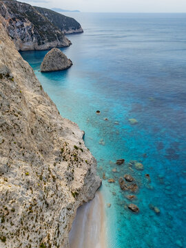 Aerial view of the rugged, towering cliffs meeting the turquoise waters of Porto Katsiki beach, Lefkada, Lefkada, Greece.