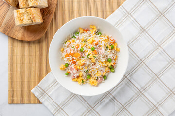Fried rice bowl with bread rolls on bamboo mat