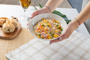 Hands serving a bowl of classic fried rice