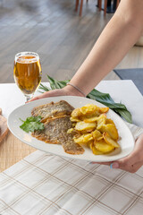 Serving fried fish and potatoes with beer