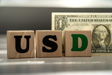 Wooden Blocks Spelling USD with U.S. Dollar Bill in Background Representing Currency, Finance, Investment, and Economic Concepts in Banking and Wealth Management