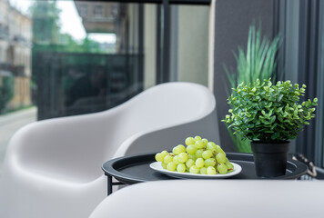Minimalist Home Outdoor Table Setting with Grapes and Decorative Plant on a Patio