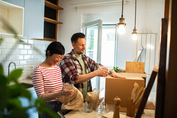 Young couple unpacking in new kitchen