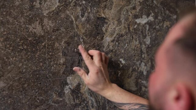 Tiler installing large format tile on bathroom wall