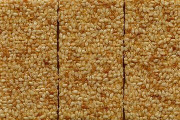 Top view of three sesame seed candy bars as a background texture. Close-up, flat lay.