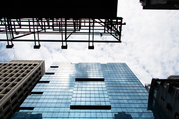 Landscapes gap between large building structure in business district in big city. Architecture of construction. Window glass top with sky white clouds and bright sunlight shining through is background