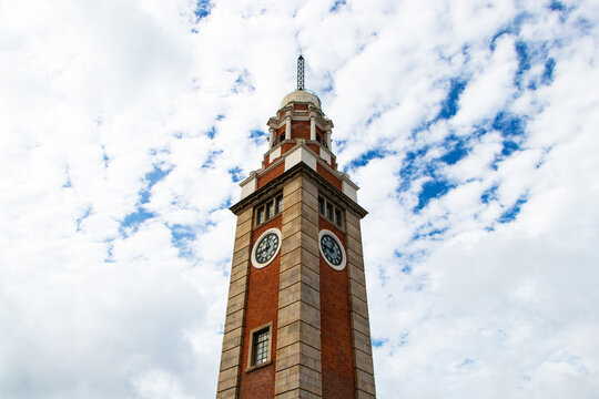 Landscape remote photo of clock tower notify time in park with sky blue sunlight with white clouds is background. Landmark famous became symbol of park Hong Kong.