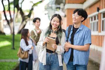 Happy university students walking together on campus, enjoying friendship and good vibes.
